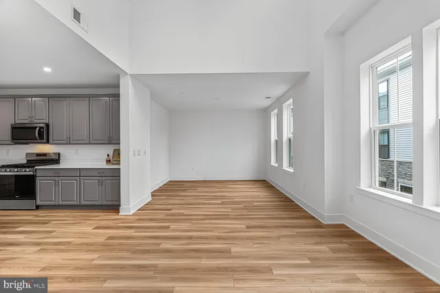 a view of a kitchen with wooden floor and electronic appliances