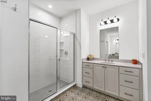 a bathroom with a shower sink and mirror