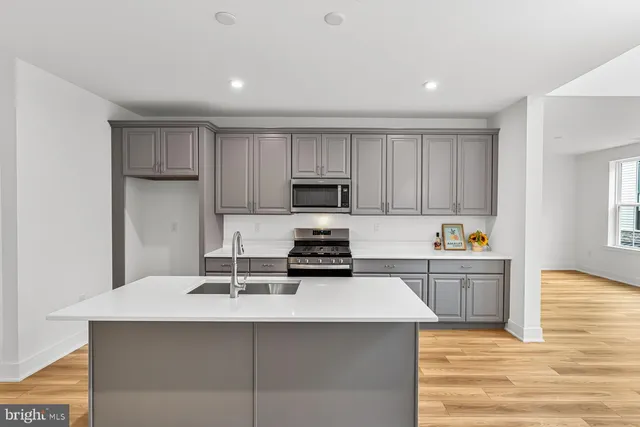 a kitchen with a sink a stove and cabinets