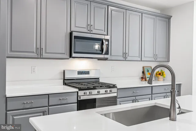 a kitchen with stainless steel appliances granite countertop a stove a microwave and cabinets