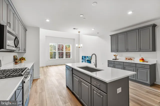 a kitchen with sink cabinets and wooden floor