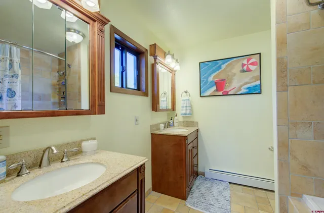 a bathroom with a granite countertop sink a mirror and a shower