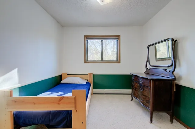 a bedroom with a bed and a dresser next to it