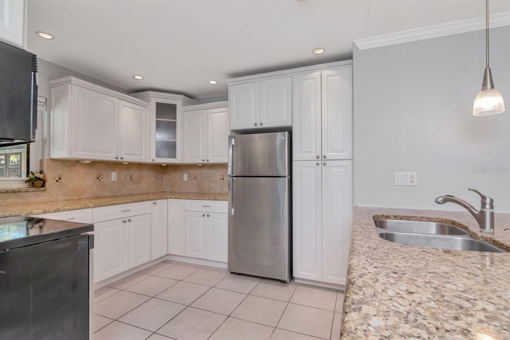 2650 Countryside Boulevard, Unit F303 Clearwater, FL 33761 - Photo 17 of 39 a kitchen with a refrigerator sink and cabinets