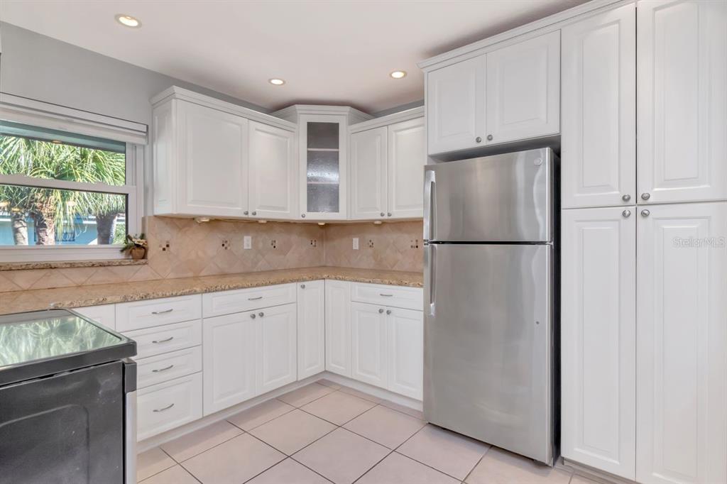 2650 Countryside Boulevard, Unit F303 Clearwater, FL 33761 - Photo 18 of 39 a kitchen with white cabinets and refrigerator