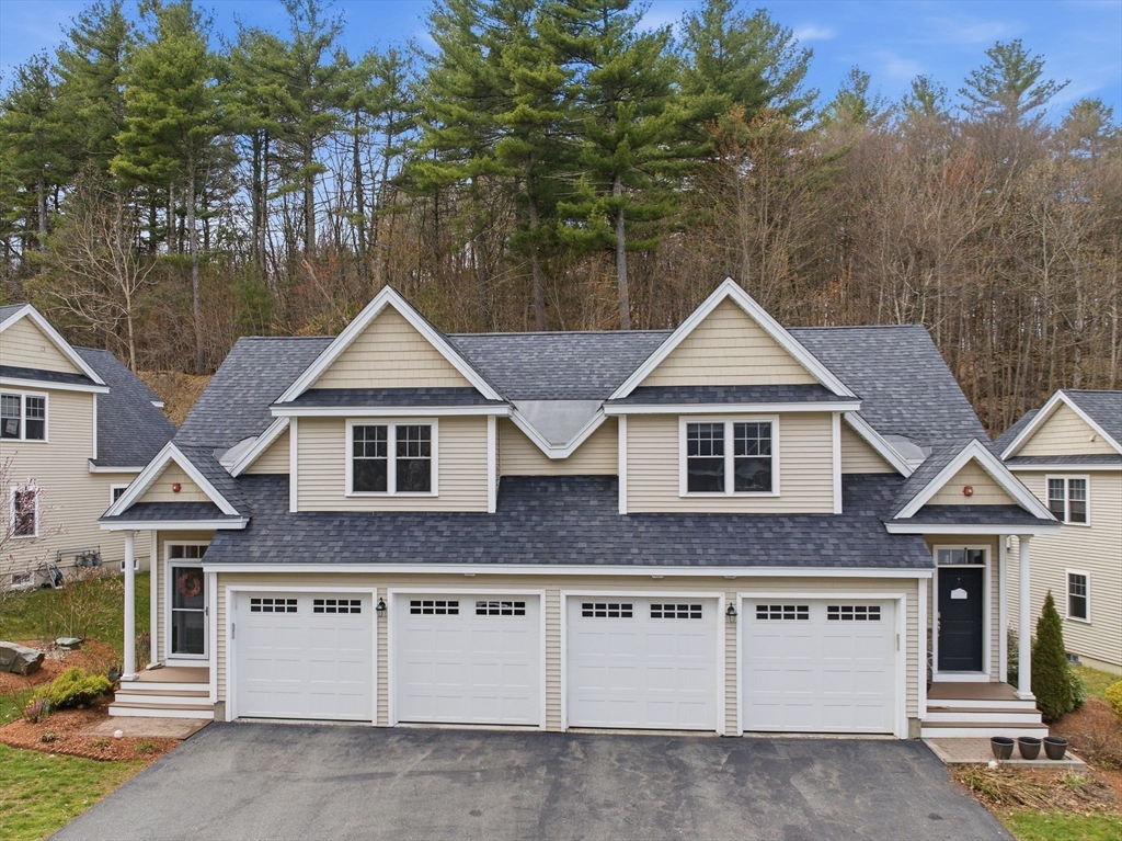 6 Trail Ridge Way, Unit D Harvard, MA 01451 - Photo 27 of 28 a front view of a house with a yard and garage
