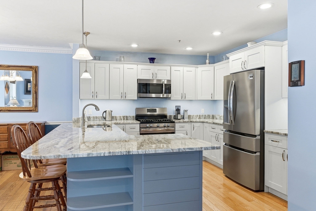 6 Trail Ridge Way, Unit D Harvard, MA 01451 - Photo 5 of 28 a kitchen with stainless steel appliances granite countertop a refrigerator a stove a sink a dining table and chairs
