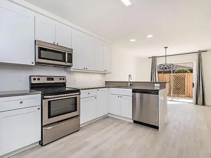 a kitchen with granite countertop a sink and steel appliances