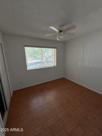 an empty room with windows and ceiling fan view