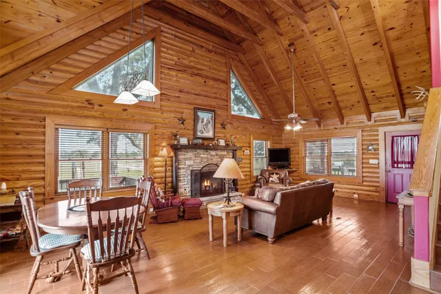 a living room with furniture and a dining table with wooden floor