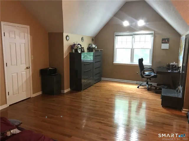 a view of a workspace with furniture and a window