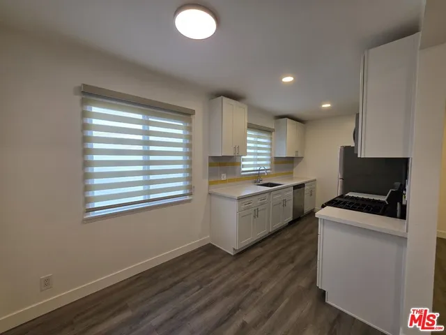 a kitchen with granite countertop white cabinets and white appliances