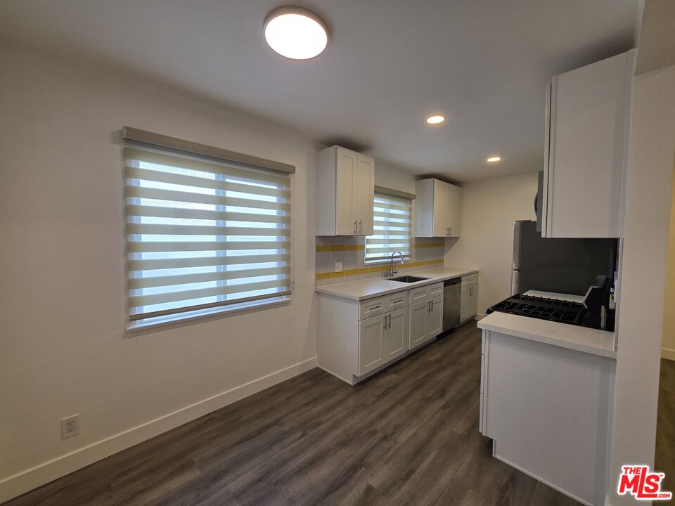 707 Strand Street, Unit 3 Santa Monica, CA 90405 - Photo 11 of 42 a kitchen with granite countertop white cabinets and white appliances