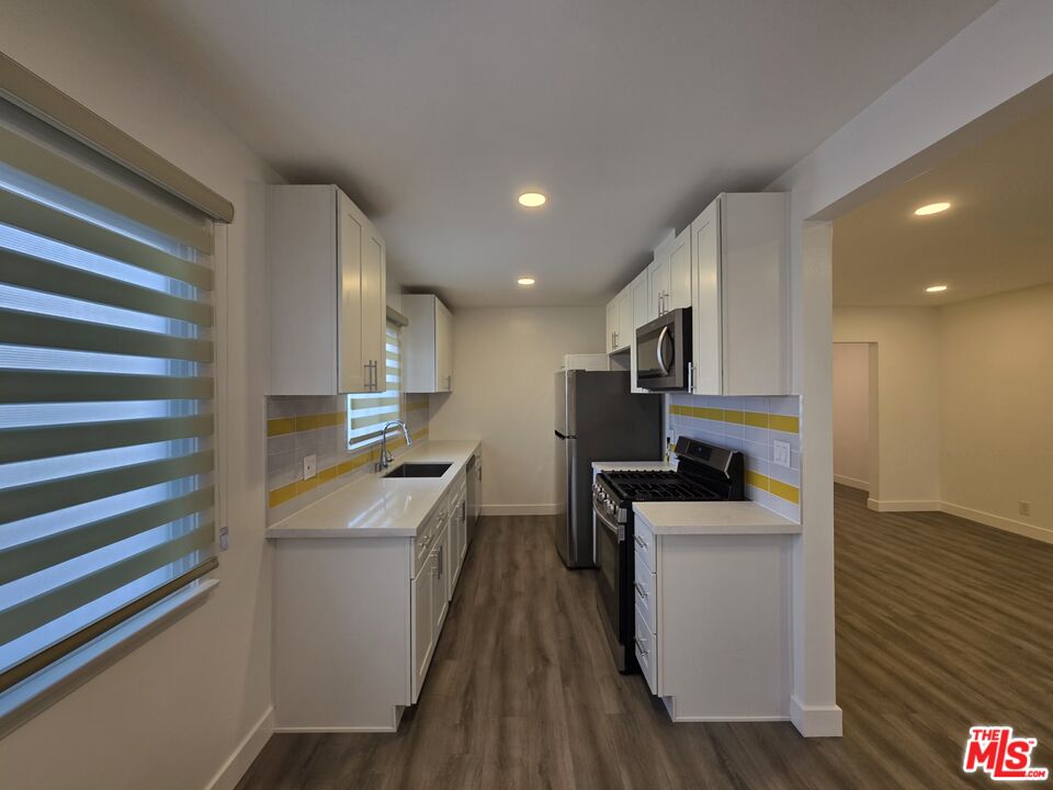 707 Strand Street, Unit 3 Santa Monica, CA 90405 - Photo 12 of 42 a kitchen that has a sink and wooden floor