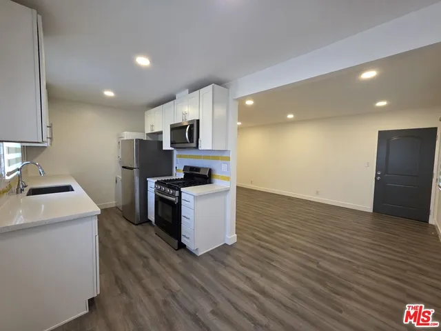 a kitchen with a sink a microwave a refrigerator and cabinets