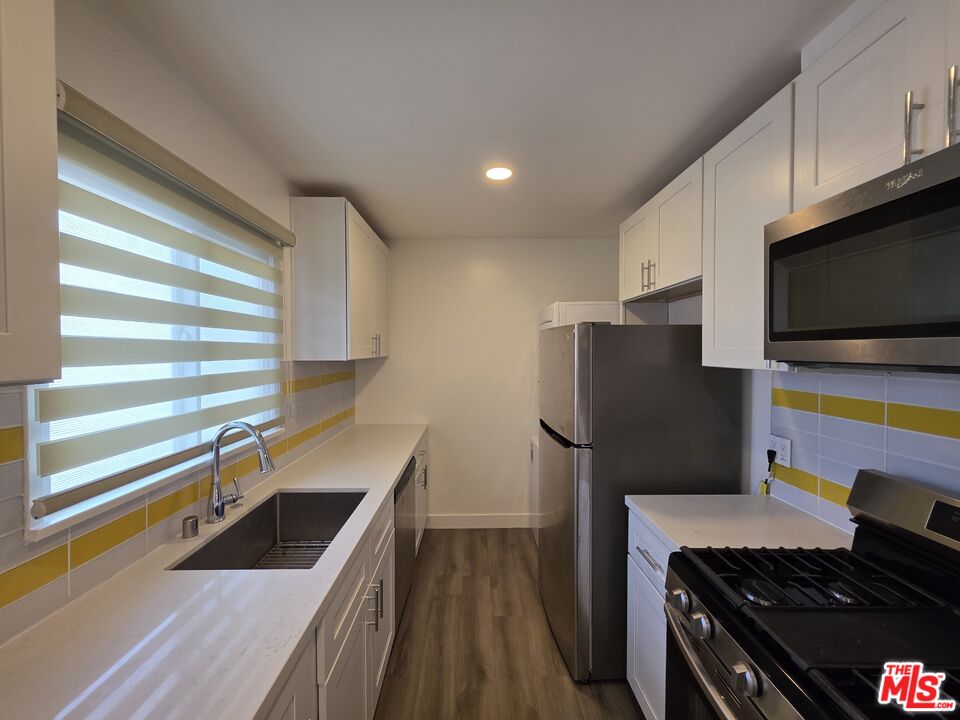 707 Strand Street, Unit 3 Santa Monica, CA 90405 - Photo 18 of 42 a kitchen with stainless steel appliances granite countertop a sink stove and refrigerator