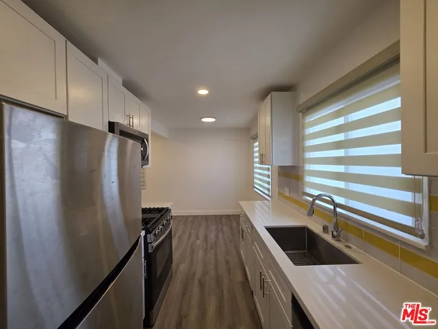 a kitchen with a sink a refrigerator and window