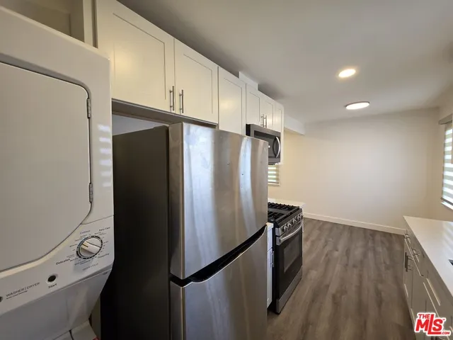 a kitchen with metallic refrigerator and sink