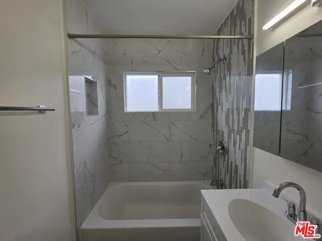a bathroom with a tub a sink and a shower