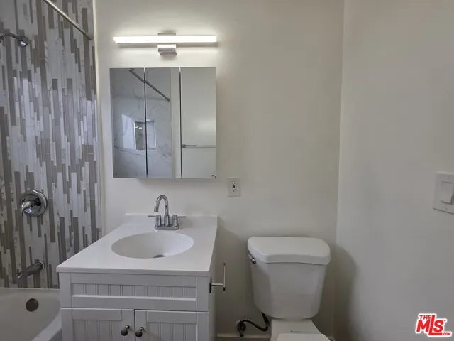 a bathroom with a sink toilet a mirror and shower
