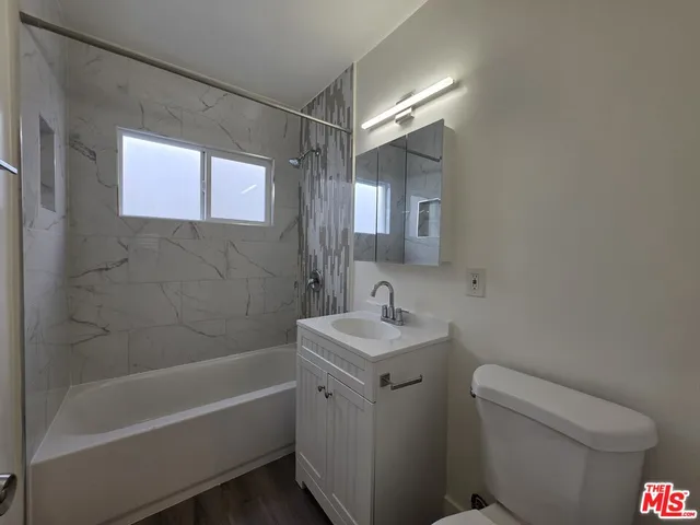 a bathroom with a sink toilet vanity and bathtub