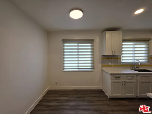 a view of a room with a sink cabinets and wooden floor