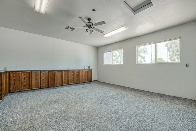 a room with a black white checkered floor with a gaming machine and dining chairs