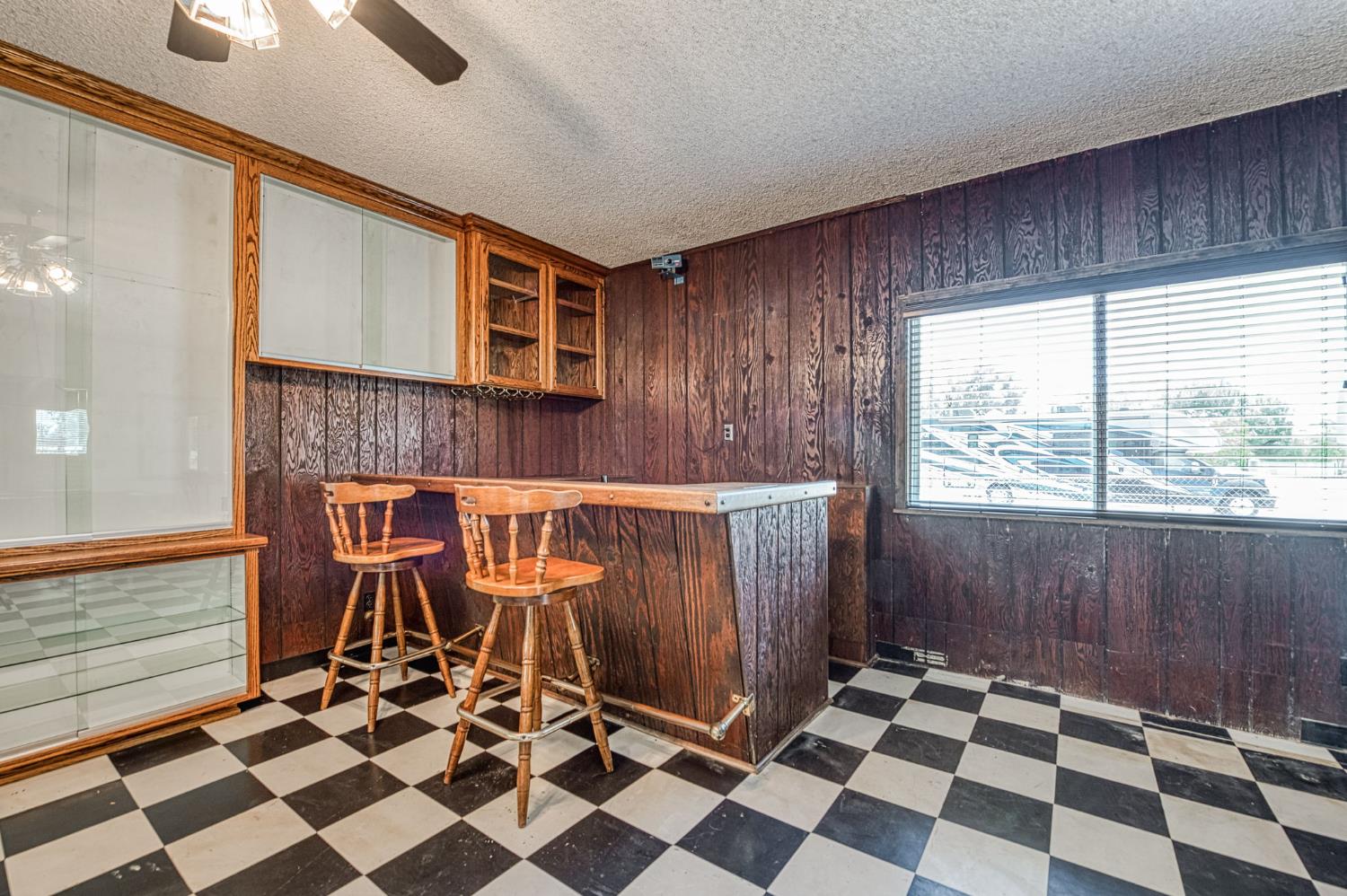 5578 Perrin Road Clovis, CA 93619 - Photo 19 of 62 a room with a black white checkered floor with a gaming machine and dining chairs