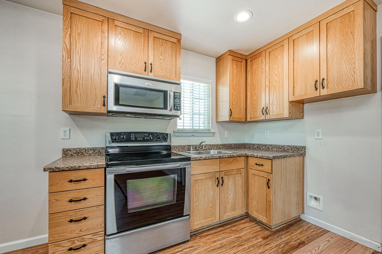 5578 Perrin Road Clovis, CA 93619 - Photo 38 of 62 a kitchen with granite countertop a stove top oven microwave and cabinets