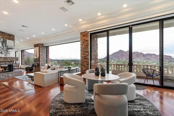 a living room with furniture a fireplace and a large window