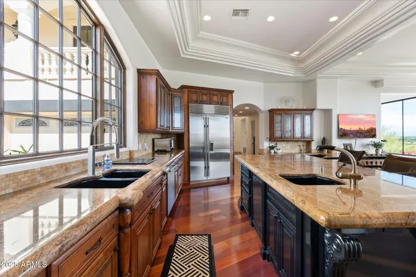 a living room with furniture large windows and wooden floor