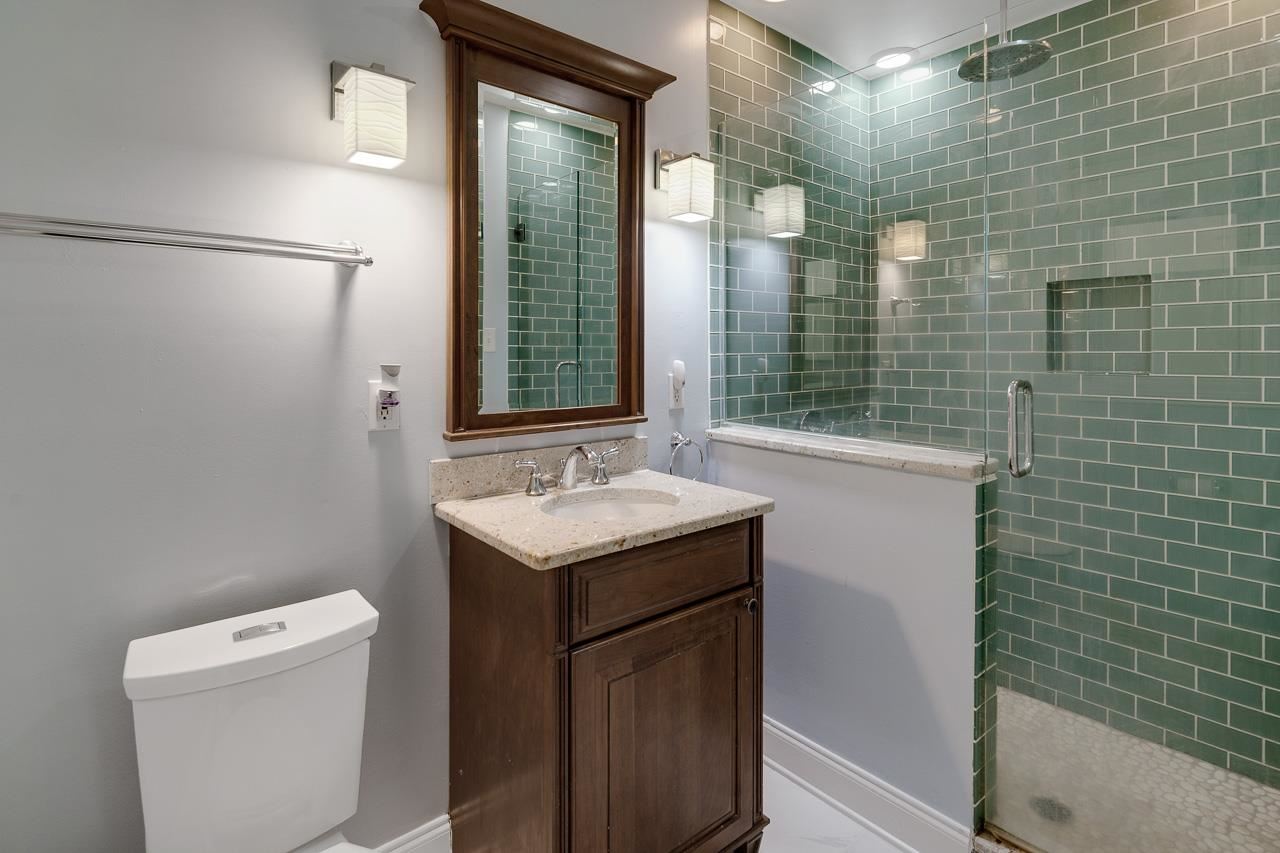 1057 Dearing Road Memphis, TN 38117 - Photo 8 of 25 Totally gutted and renovated, this bathroom features a walk-in shower, new tile floor, new vanity, and new fixtures.