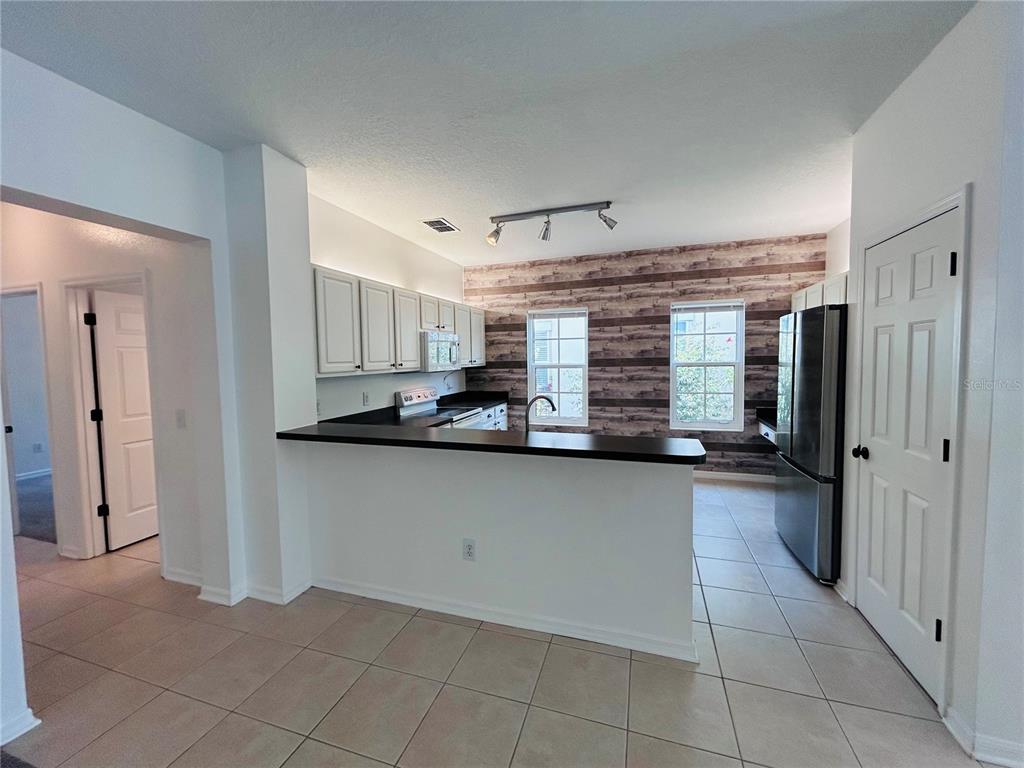 904 Pawstand Road Kissimmee, FL 34747 - Photo 11 of 22 a kitchen with stainless steel appliances granite countertop a refrigerator and a sink