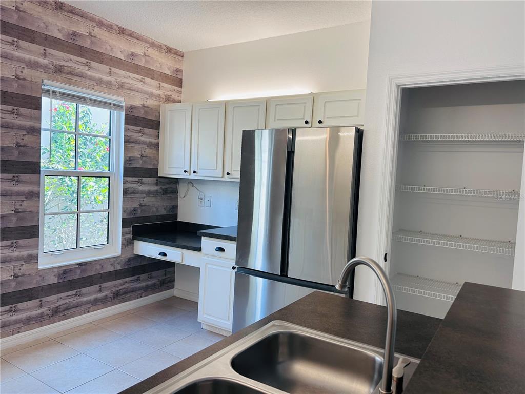 904 Pawstand Road Kissimmee, FL 34747 - Photo 13 of 22 a kitchen with stainless steel appliances granite countertop a refrigerator and a sink