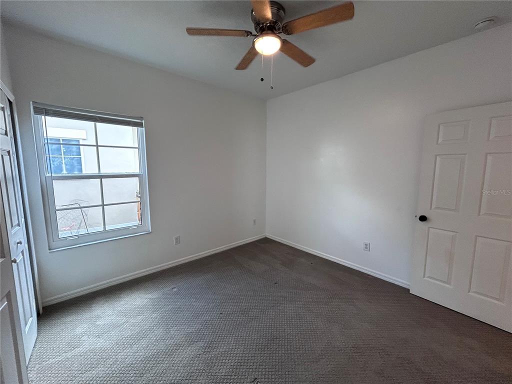 904 Pawstand Road Kissimmee, FL 34747 - Photo 16 of 22 an empty room with chandelier fan and windows