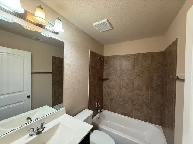 an empty room with a window and a ceiling fan