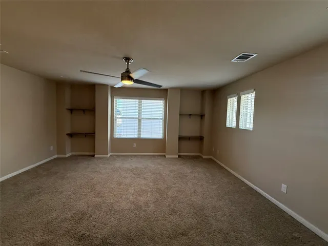 a view of an empty room with a fireplace and a window