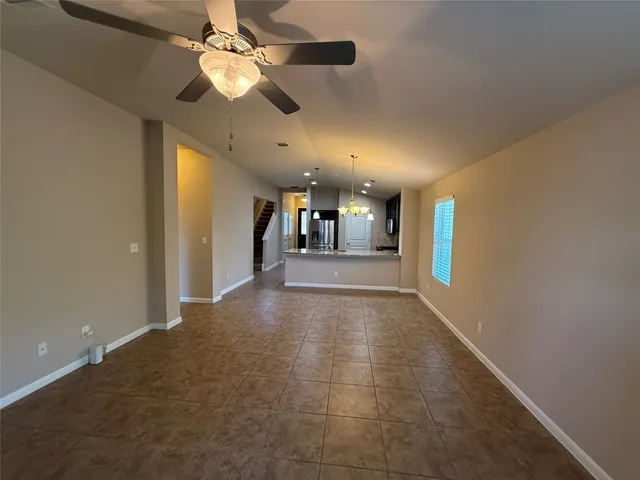 a view of a hallway with a chandelier fan and table