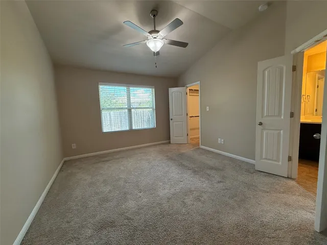 an empty room with windows and ceiling fan