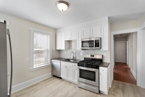 a kitchen with stainless steel appliances a stove a microwave a sink and cabinets