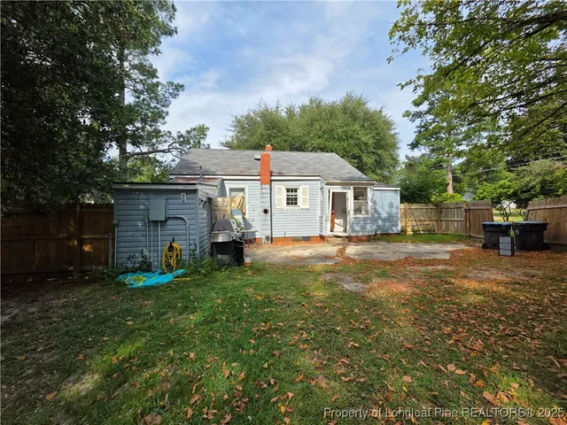 a front view of a house with a garden and trees
