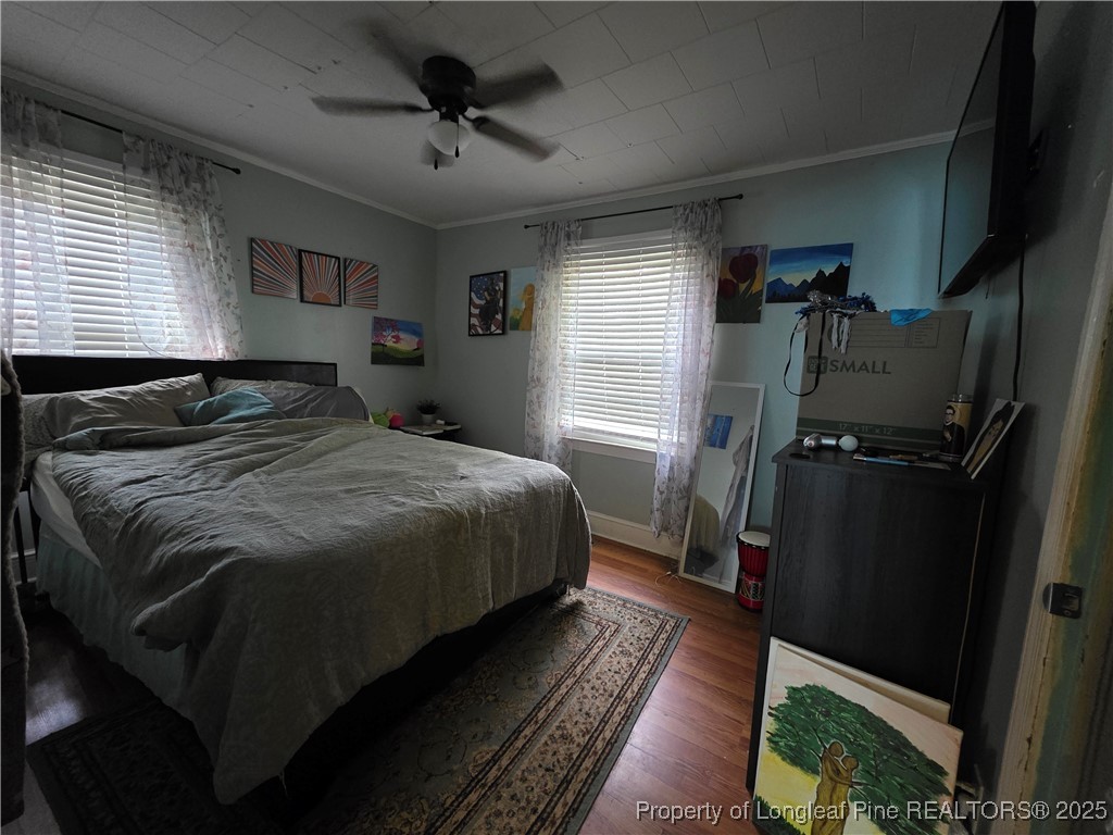 124 North Wright Street Raeford, NC 28376 - Photo 5 of 17 a bedroom with a bed and wooden floor