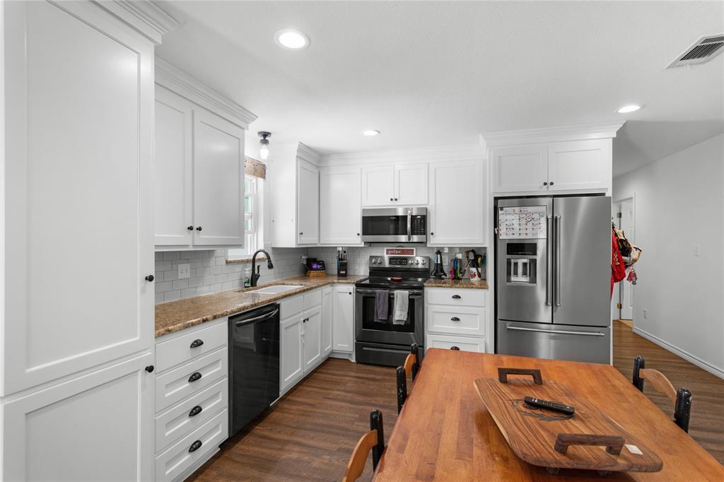 900 Bosque Street Meridian, TX 76665 - Photo 11 of 30 a kitchen with stainless steel appliances a refrigerator sink and cabinets