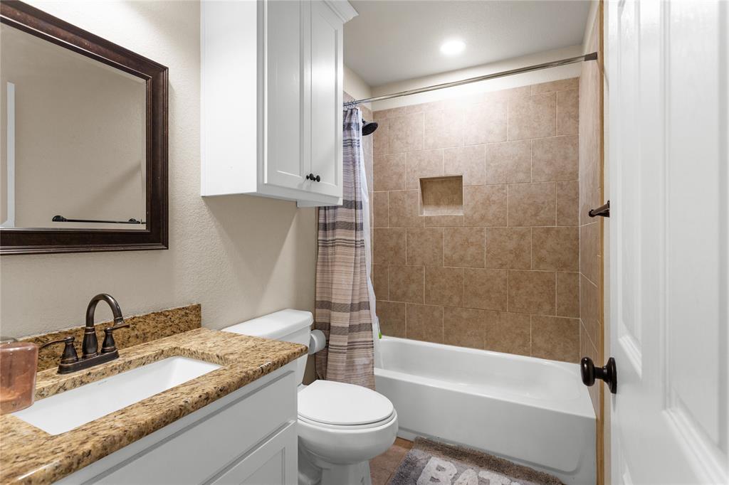 900 Bosque Street Meridian, TX 76665 - Photo 18 of 30 a bathroom with a granite countertop sink toilet and shower