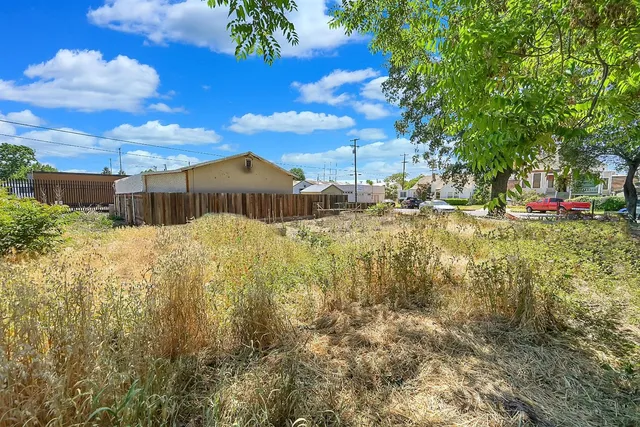 a view of a yard with wooden fence