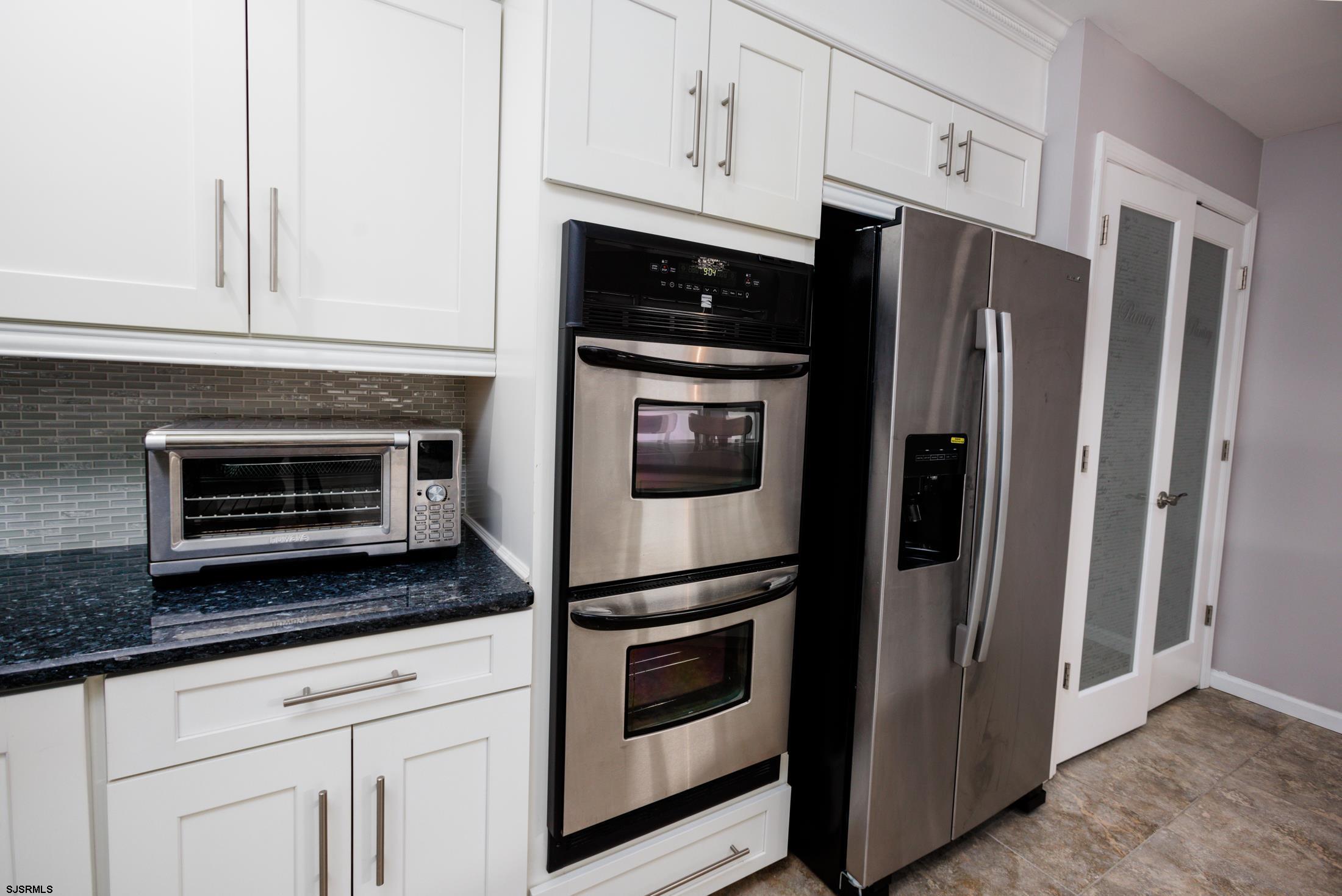 816 Chelsea Road Absecon, NJ 08201 - Photo 11 of 41 a kitchen with granite countertop white cabinets and stainless steel appliances