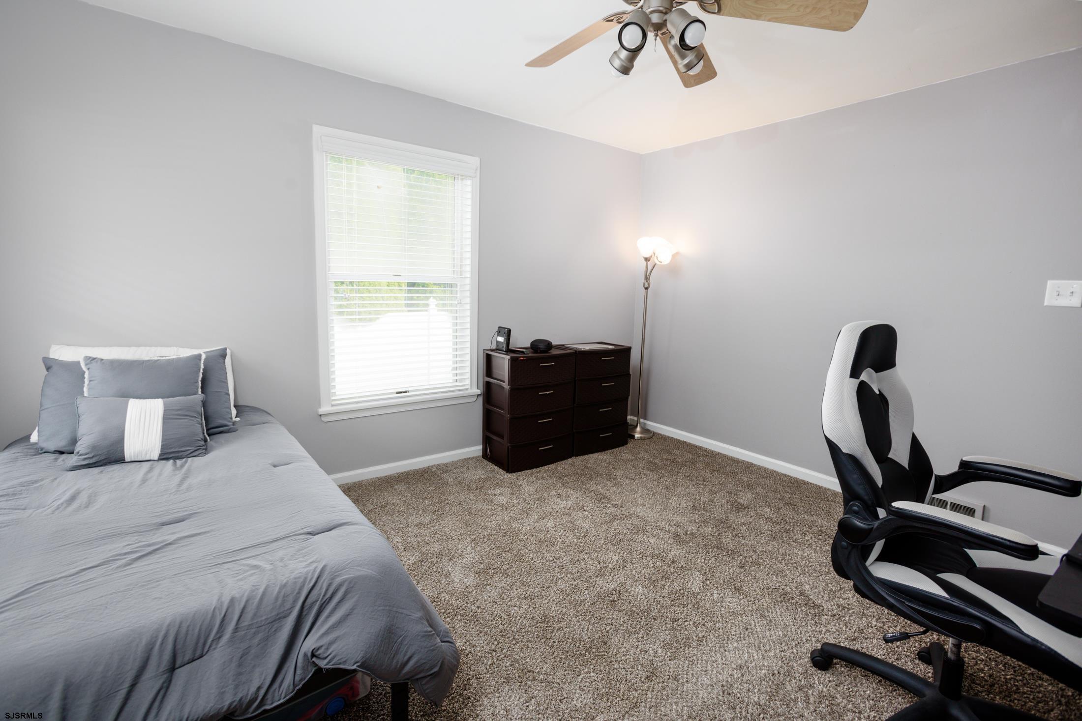 816 Chelsea Road Absecon, NJ 08201 - Photo 15 of 41 a bedroom with a bed and a chandelier