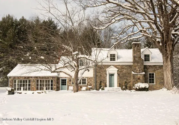 a front view of a house with a yard covered in snow