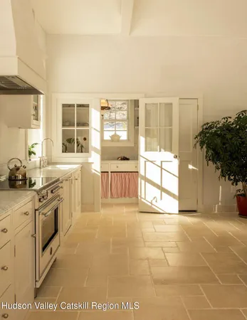 a large white kitchen with granite countertop a sink and a stove top oven