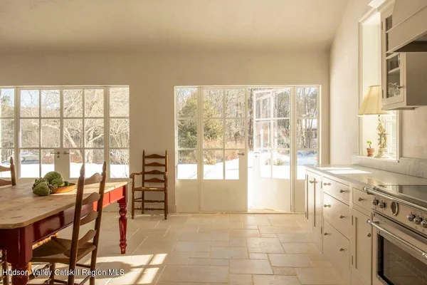 a open kitchen with granite countertop a stove top oven dining table and chairs